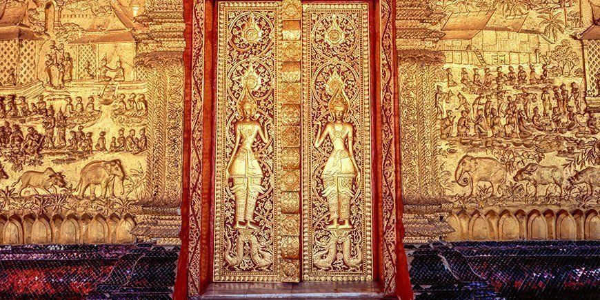 Guldpläterad, utsmyckad fasad på Wat Mai-templet i Luang Prabang