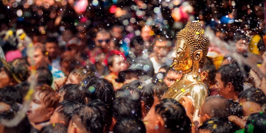 Gyllene Buddha sprutas med vatten under Songkran-festivalen i Thailand