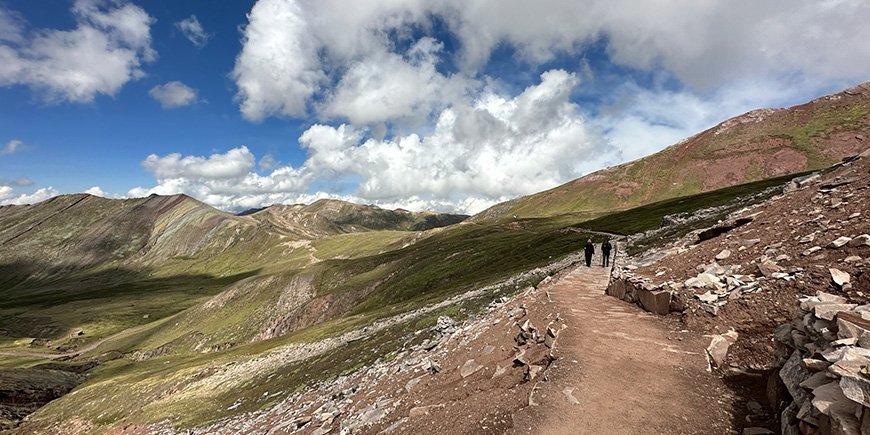 Två personer vandrar på Rainbow Mountain i Peru