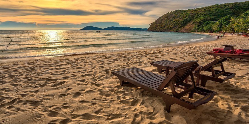 Solnedgång och solstolar vid Ao Prao Beach på Koh Samet, Thailand.