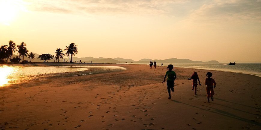 Barn som leker på stranden på Koh Yao Yai