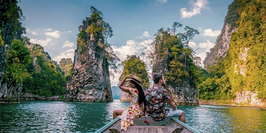 Kvinna och man seglar på sjön i Khao Sok nationalpark i Thailand