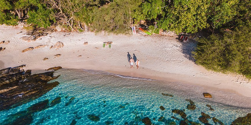 Par som håller varandra i handen på stranden på Koh Samet