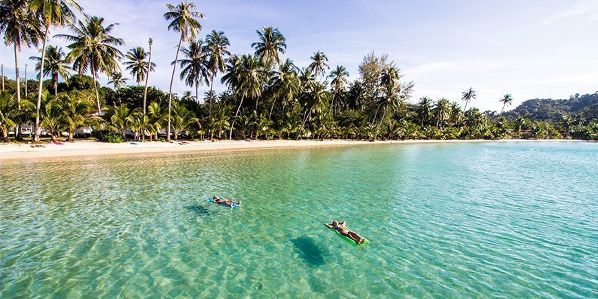 Människor som kopplar av i vattnet på stranden på Koh Kood