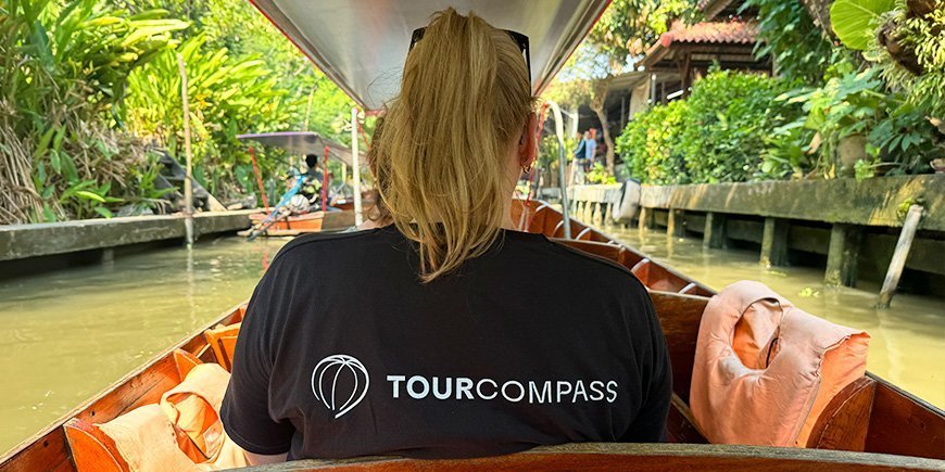 Kvinna i TourCompass-t-shirt sitter i båt med ryggen vänd