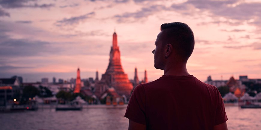 Man står framför Wat Arun i Thailand vid solnedgången