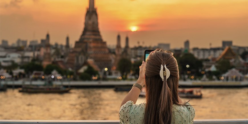 Kvinna tar foto av Wat Arun i Bangkok