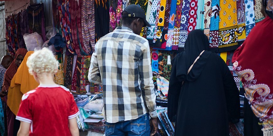 Pojke går bland lokalbefolkningen på marknaden i Stone Town