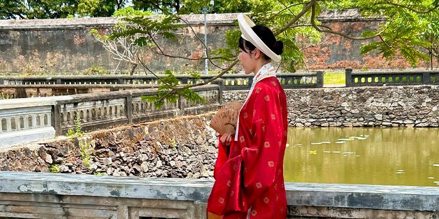 Kvinna klädd i vackra kläder i kejsarstaden i Hue, Vietnam.
